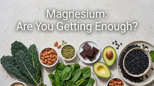 Magnesium-rich foods including leafy greens, almonds, pumpkin seeds, dark chocolate and avocado arranged on a stone surface