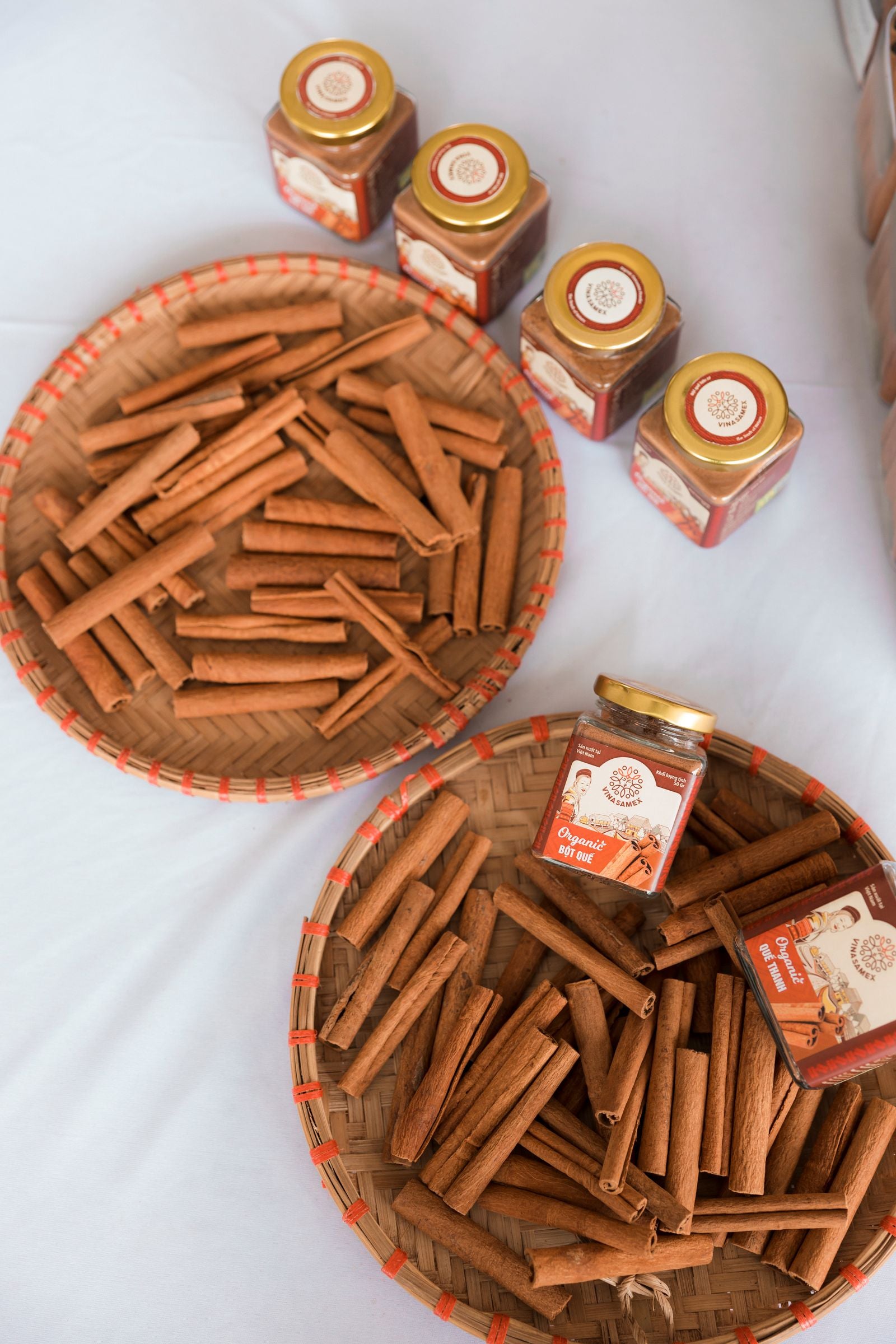 Cinnamon sticks and spice jars arranged on a woven basket, representing natural ingredients that support balanced blood sugar